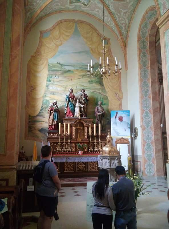 Praying before the baptismal font where Saint John Paul II was baptized